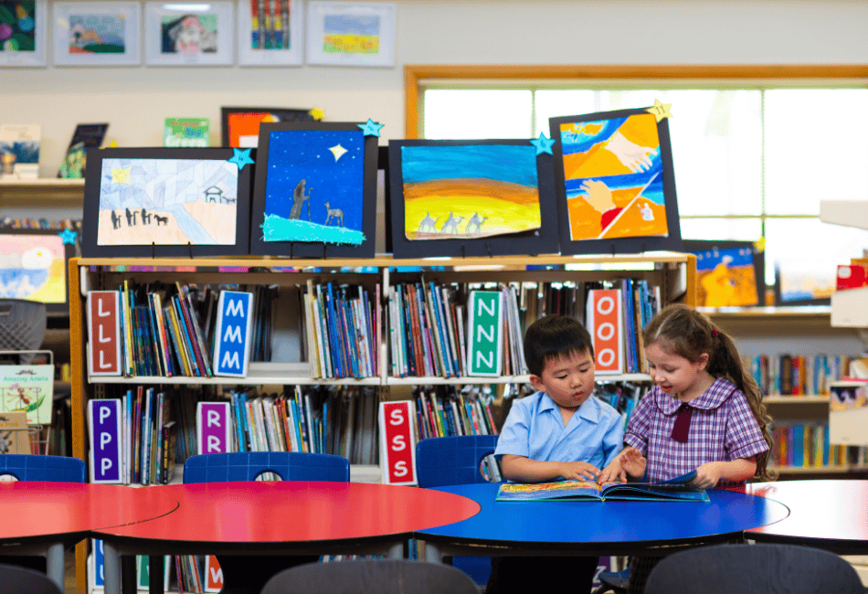 Two students from Sacred Heart Catholic Primary School Villawood reading and learning in the school library